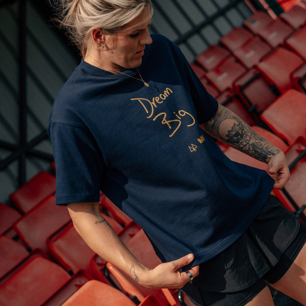 Woman in a navy blue t-shirt with text in red seats