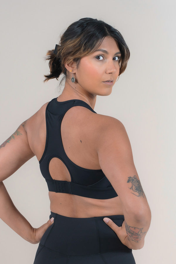 Athlete show the back straps of the Black Empower Sports Bra