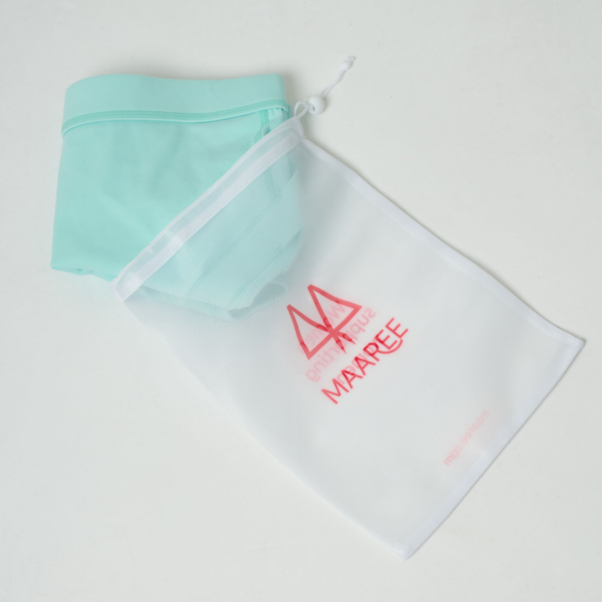 White wash bag with MAAREE branding containing a Spearmint Sports Bra