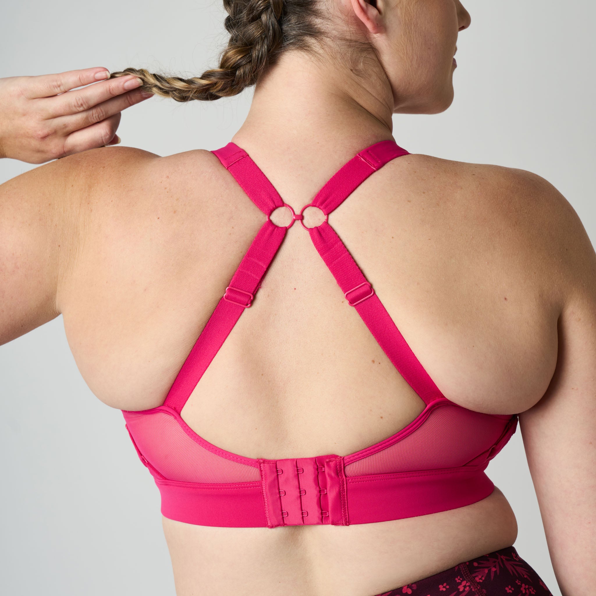 Person wearing a pink sports bra with a plain background
