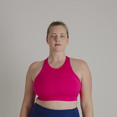 Person wearing a bright pink sports bra against a neutral background